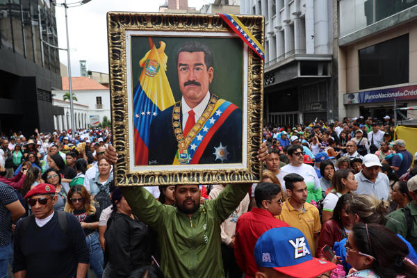 oficialista con un cuadro de Maduro
